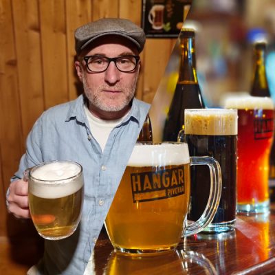 Person mit gefülltem Bierkrug in der Hand in der linken Bildhälfte sowie drei Bierflaschen und drei gefüllte Biergläser in einer Reihe auf einem Holztresen in der rechten Bildhälfte